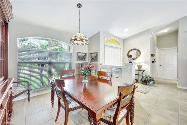 Dining space featuring light tile patterned flooring and lofted ceiling