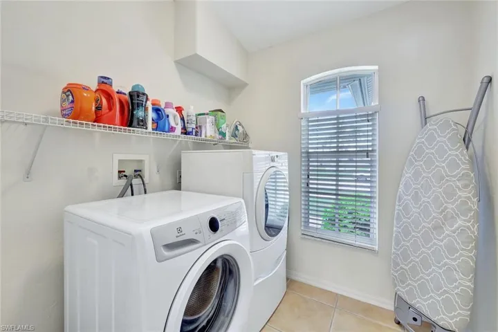 Washroom featuring washer and clothes dryer and light tile patterned floors