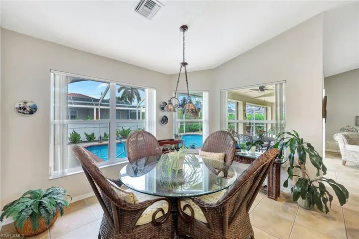 Tiled dining space with lofted ceiling, ceiling fan, and plenty of natural light