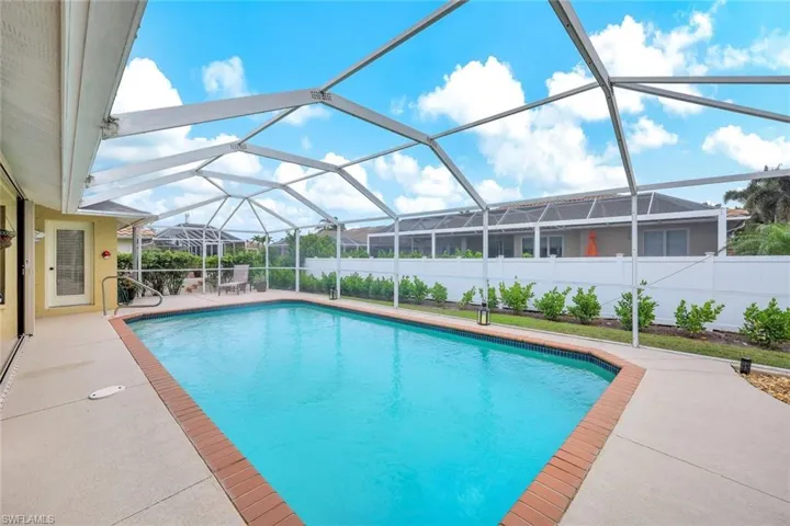 View of pool with a patio and glass enclosure