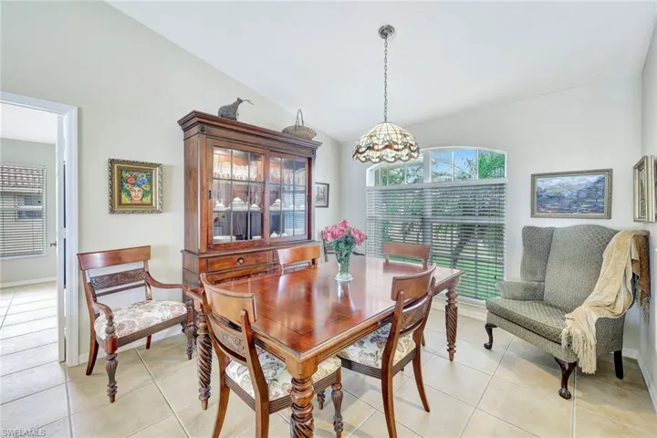 Dining space featuring vaulted ceiling and light tile patterned floors