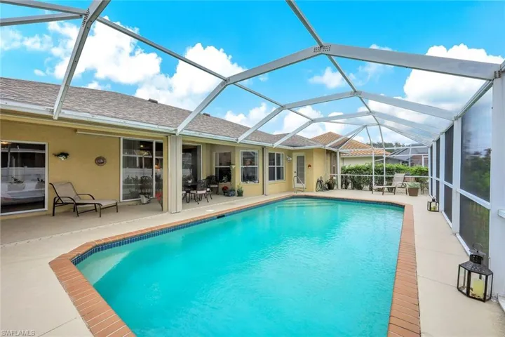 View of swimming pool featuring a patio area and glass enclosure