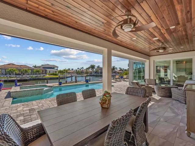 View of patio featuring an in ground hot tub, a water view, and ceiling fan