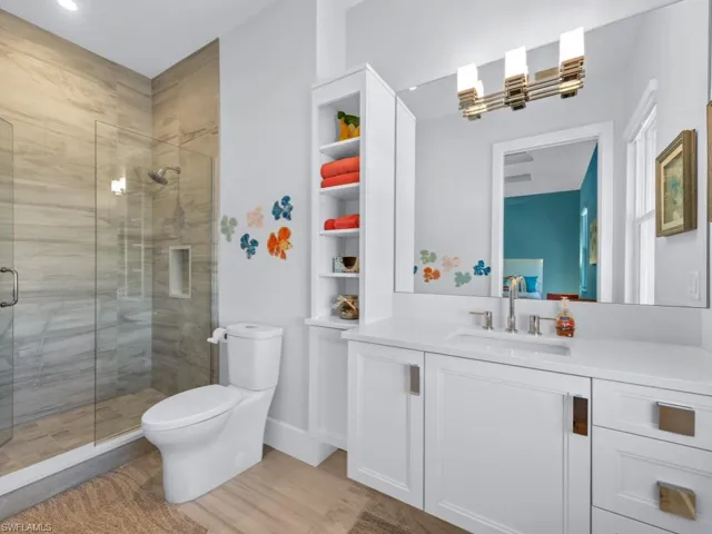 Bathroom with vanity, wood-type flooring, an enclosed shower, and toilet