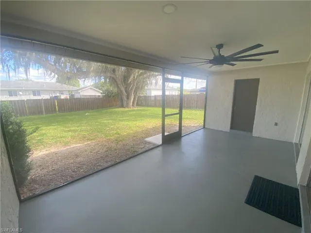 Unfurnished sunroom with a patio and a ceiling fan