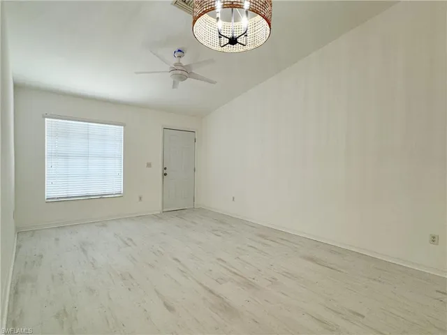Unfurnished room featuring ceiling fan, light hardwood / wood-style floors, and lofted ceiling