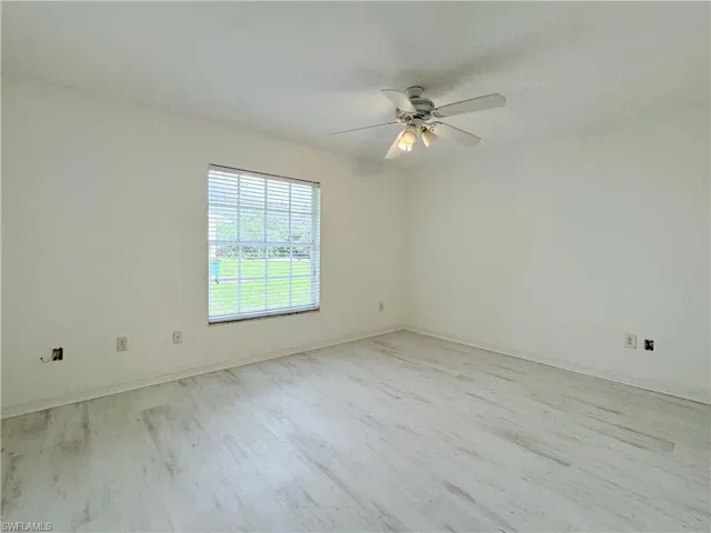 Unfurnished room with ceiling fan and light wood-type flooring