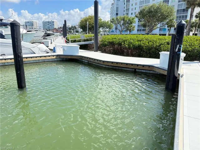 Dedicated boat slip with composite decking, black pilings, and a waterfront setting