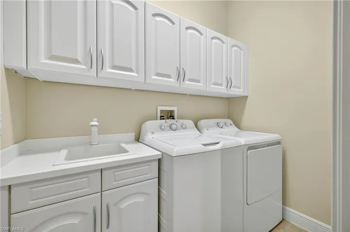 Washroom featuring cabinet space and independent washer and dryer
