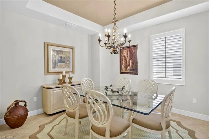 Dining area featuring light tile patterned floors and a chandelier