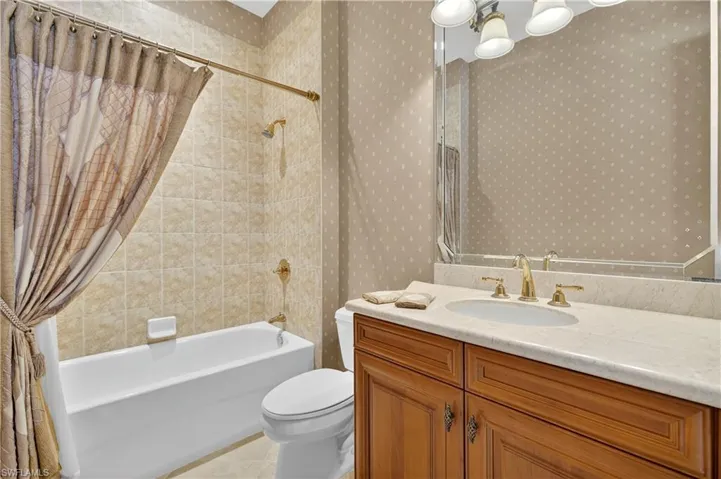 Bathroom featuring shower / tub combo, vanity, and light tile patterned floors