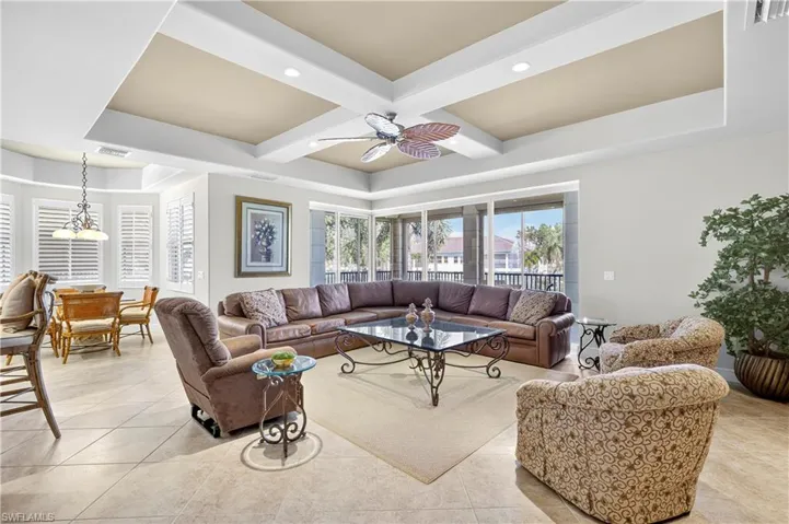 Living room featuring coffered ceiling, light tile patterned floors, beamed ceiling, recessed lighting, and ceiling fan