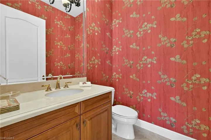 Bathroom featuring wallpapered walls, vanity, and tile patterned flooring