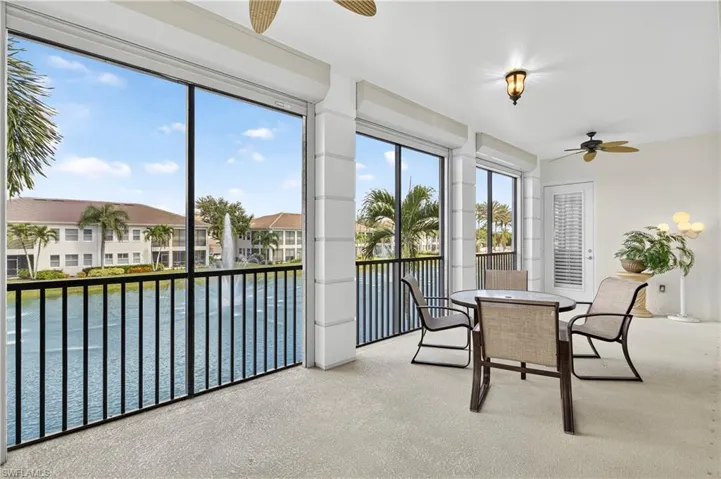 Sunroom with carpet and a water view