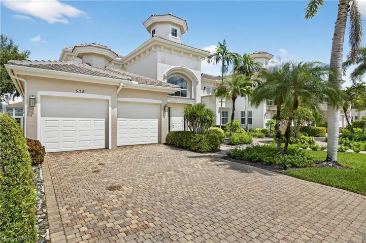 Mediterranean / spanish house with decorative driveway, stucco siding, an attached garage, and a tiled roof