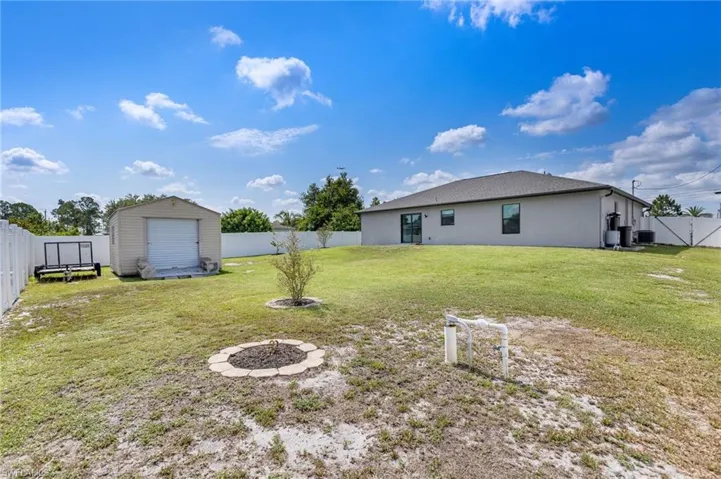 View of yard with an outdoor fire pit and cooling unit