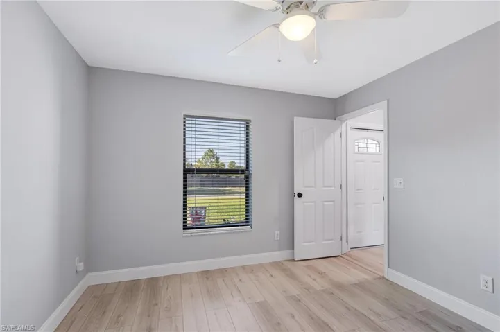 Unfurnished bedroom with light wood-style floors, baseboards, and a ceiling fan