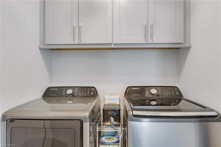 Laundry area with cabinet space and washer and clothes dryer