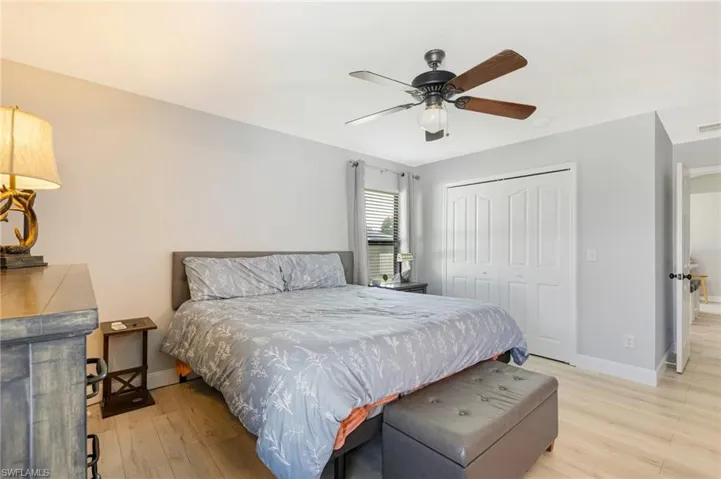 Bedroom featuring a closet, light wood-style floors, baseboards, and ceiling fan