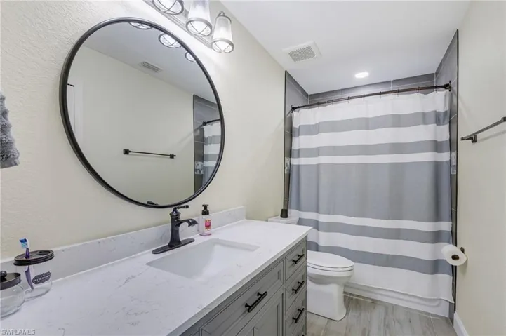 Full bath featuring vanity, toilet, and a shower with shower curtain