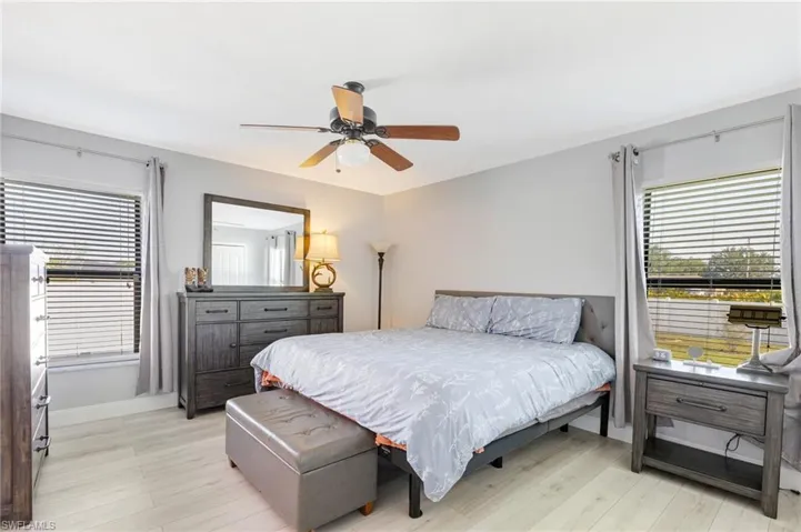 Bedroom with light wood-style flooring, baseboards, and ceiling fan