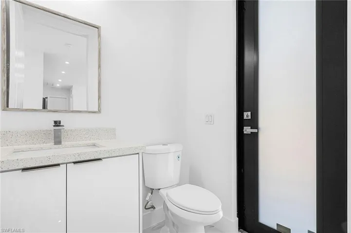 Half bathroom with toilet and vanity