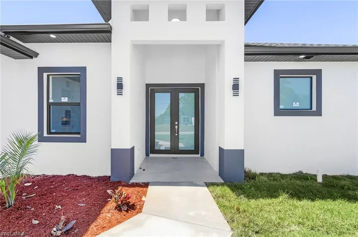 Entrance to property featuring french doors and stucco siding