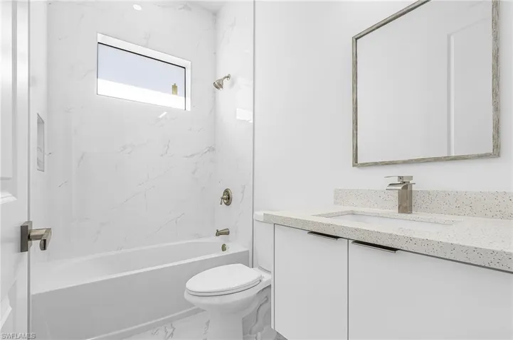 Bathroom featuring vanity,  shower combination, and marble finish floors