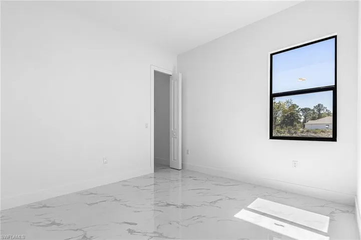 Unfurnished room with baseboards and light marble finish floors