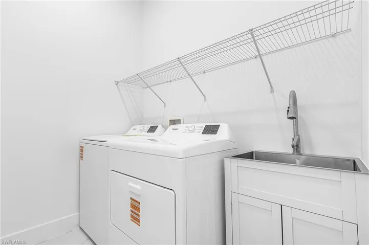 Laundry room featuring a sink and independent washer and dryer