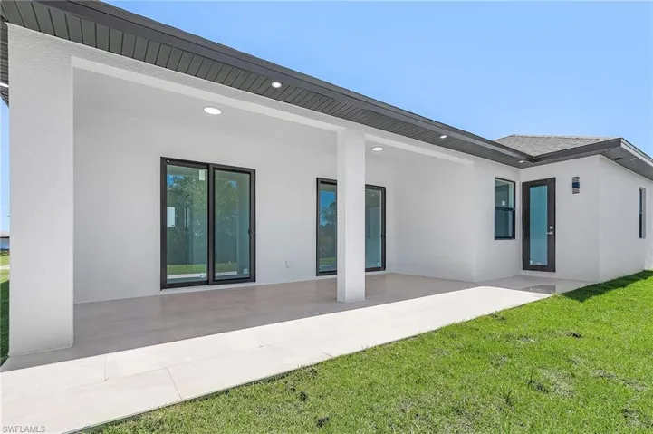 Back of property with a yard, a patio, and stucco siding