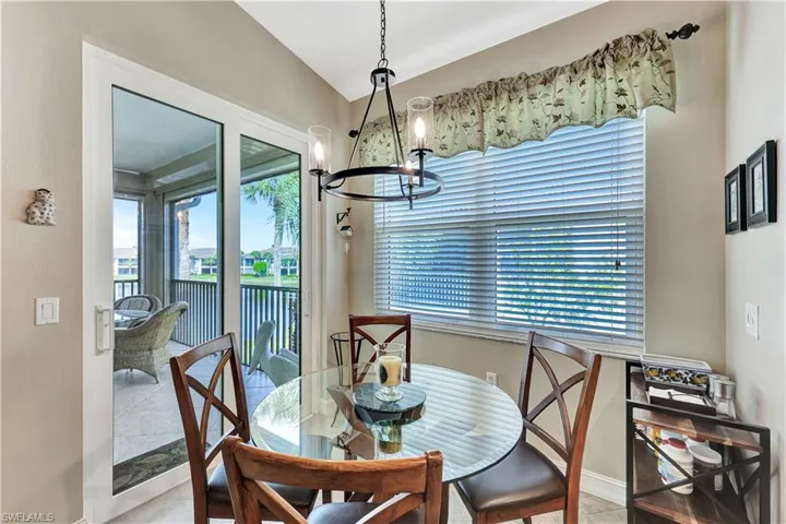Dining room featuring an inviting chandelier, light tile patterned floors, and lofted ceiling