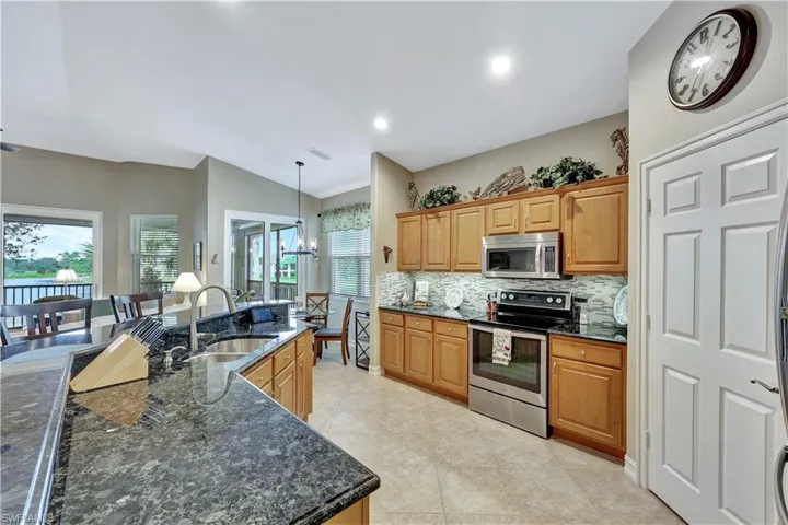 Kitchen with appliances with stainless steel finishes, a healthy amount of sunlight, sink, hanging light fixtures, and vaulted ceiling