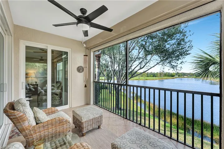 Sunroom / solarium with ceiling fan and a water view