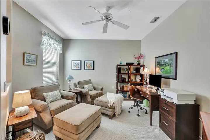 Office with ceiling fan and light colored carpet