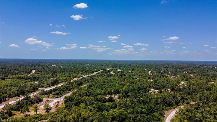 Birds eye view of property featuring a wooded view
