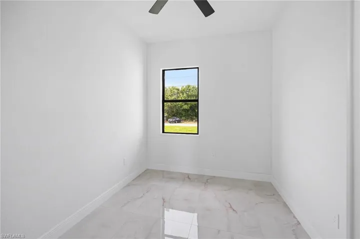 Tiled spare room with ceiling fan