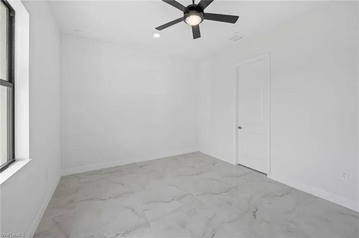 Tiled empty room with ceiling fan