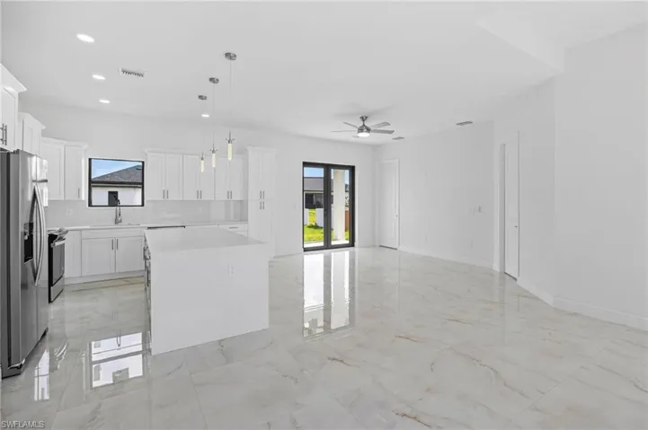 Kitchen featuring a center island, stainless steel fridge, and light tile floors