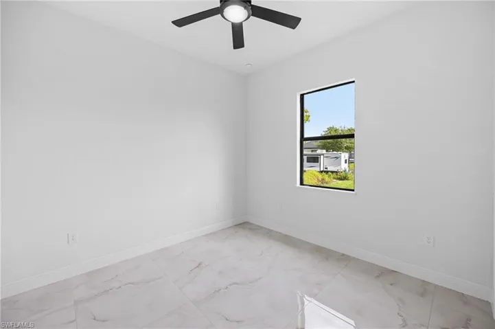 Unfurnished room featuring ceiling fan and light tile floors