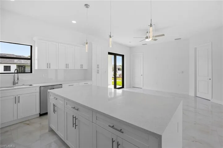 Kitchen with a kitchen island, dishwasher, ceiling fan, white cabinets, and light tile floors