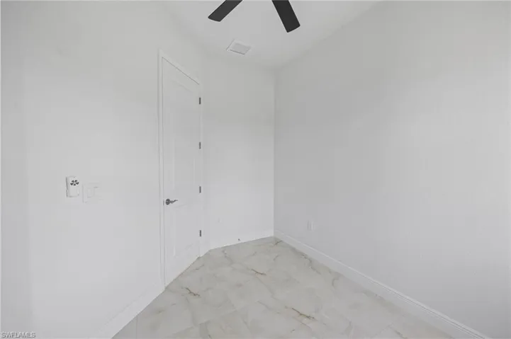 Empty room featuring ceiling fan and light tile floors