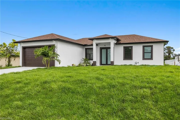 View of front of property with a garage and a front yard