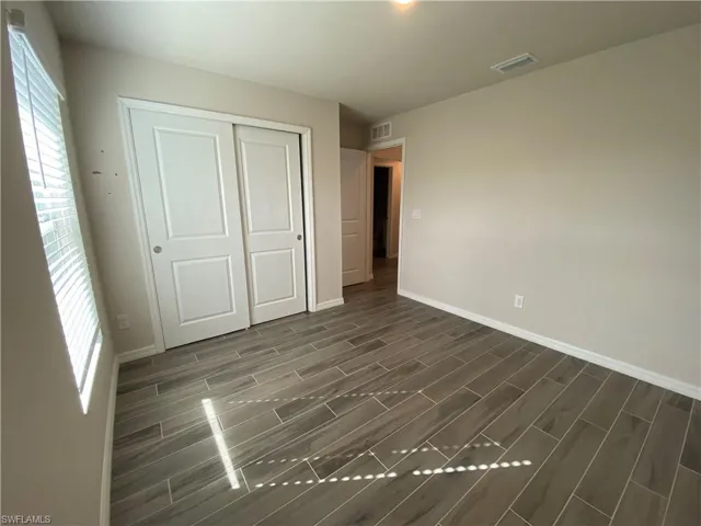 Unfurnished bedroom featuring wood tiled floors and a closet