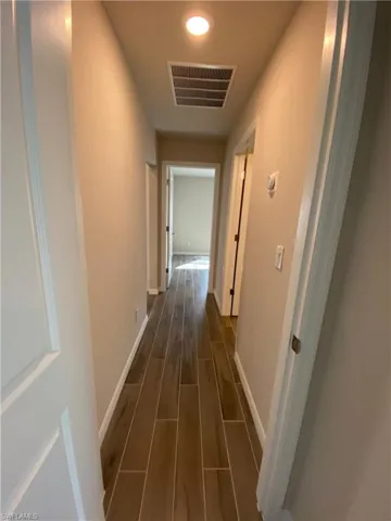 Corridor featuring wood finish floors and baseboards