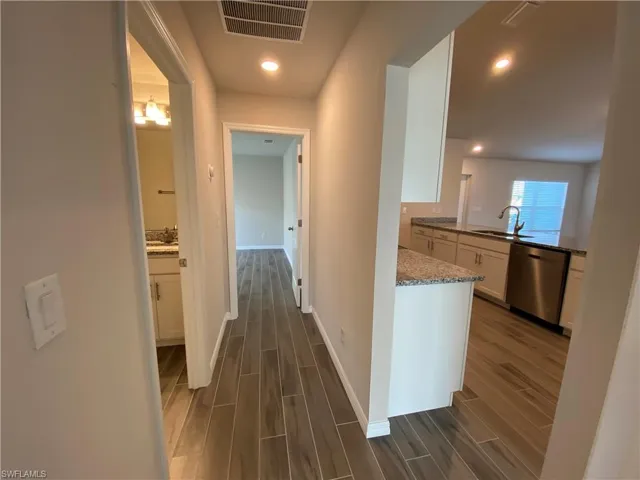 Hall with wood finish floors and recessed lighting