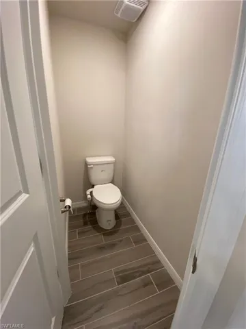 Bathroom featuring wood finish floors and toilet