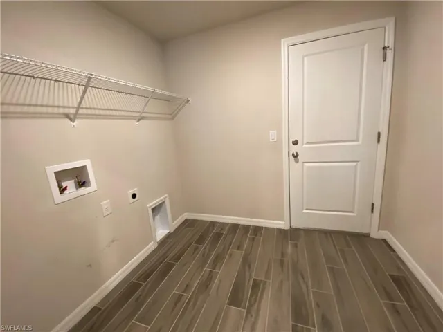 Laundry area with hookup for an electric dryer, wood finish floors, and washer hookup