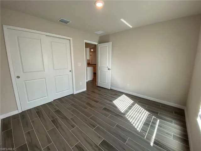 Unfurnished bedroom featuring wood tiled floors and a closet