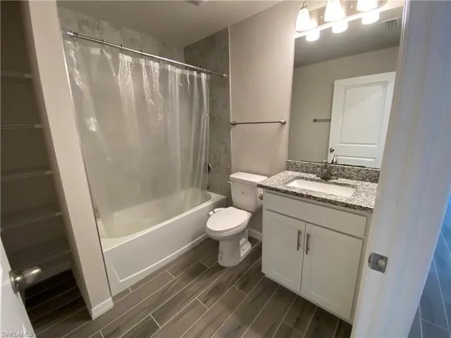 Bathroom with vanity, wood tiled floors, and shower / bath combo